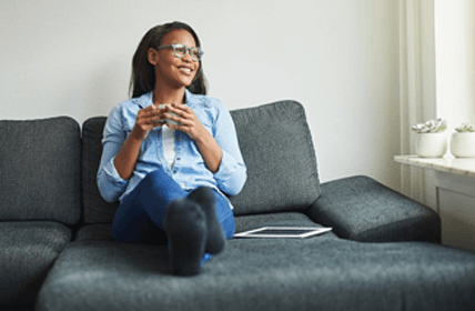 Jolly individual sitting down on couch.